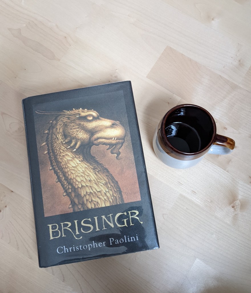 Brisingr by Christopher Paolini and a coffee mug.